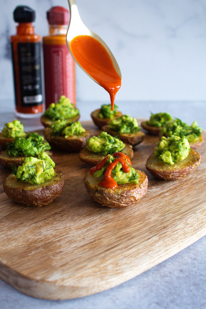 Finished Crispy Potatoes topped with avocado and hot sauce