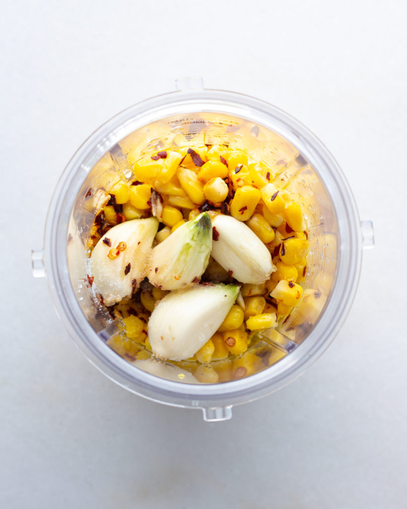 corn and garlic with seasonings in blender
