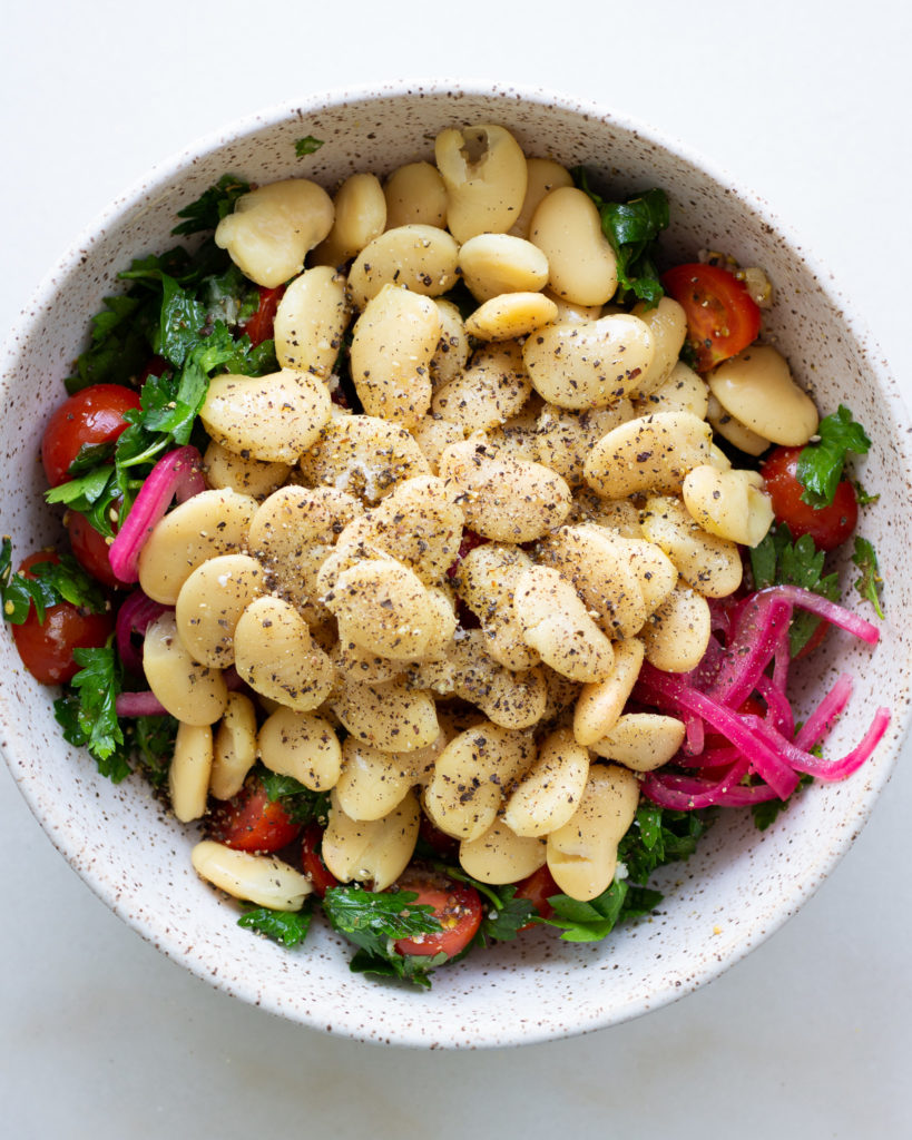 Butter beans and pepper added to bowl
