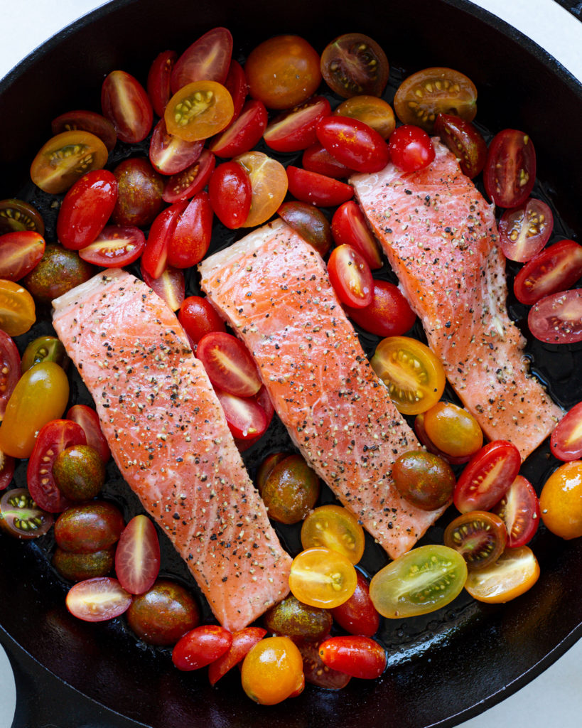 Salmon and tomatoes in pan