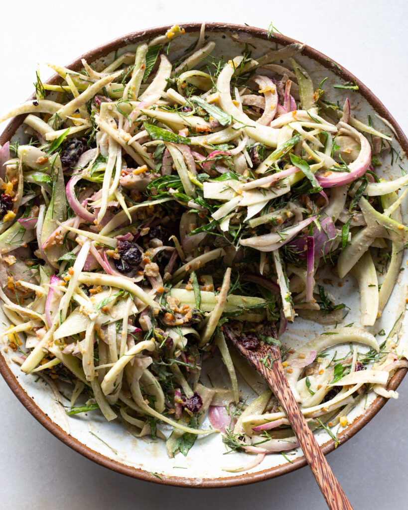 Mixing a fennel salad.