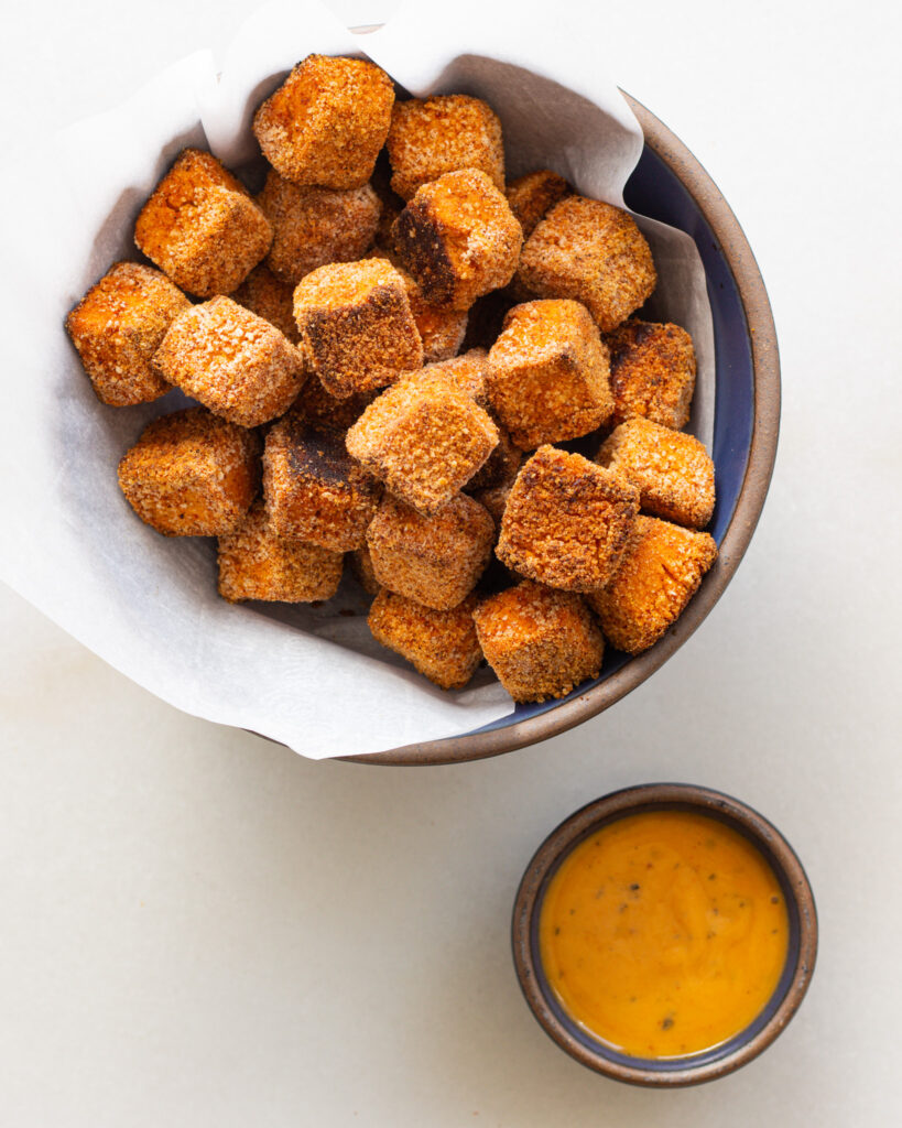 hummus nuggets in a bowl with a side of dipping sauce