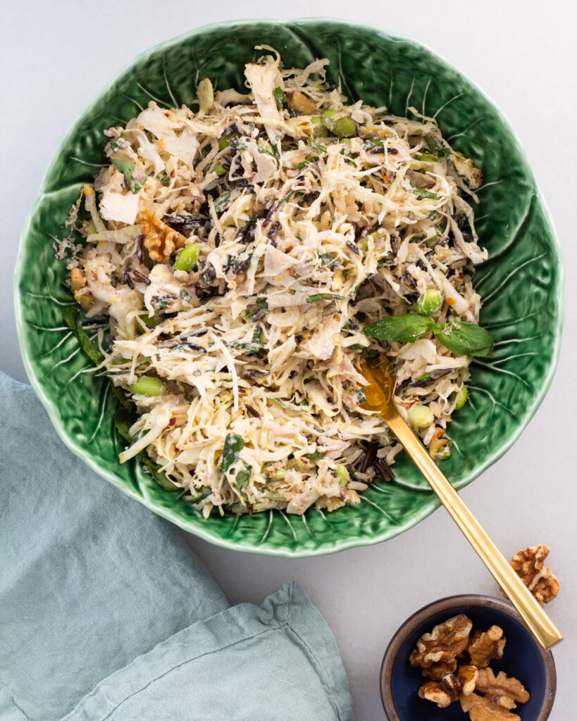 finished cabbage salad tossed with charred lemon dressing in a cabbage bowl with a gold fork