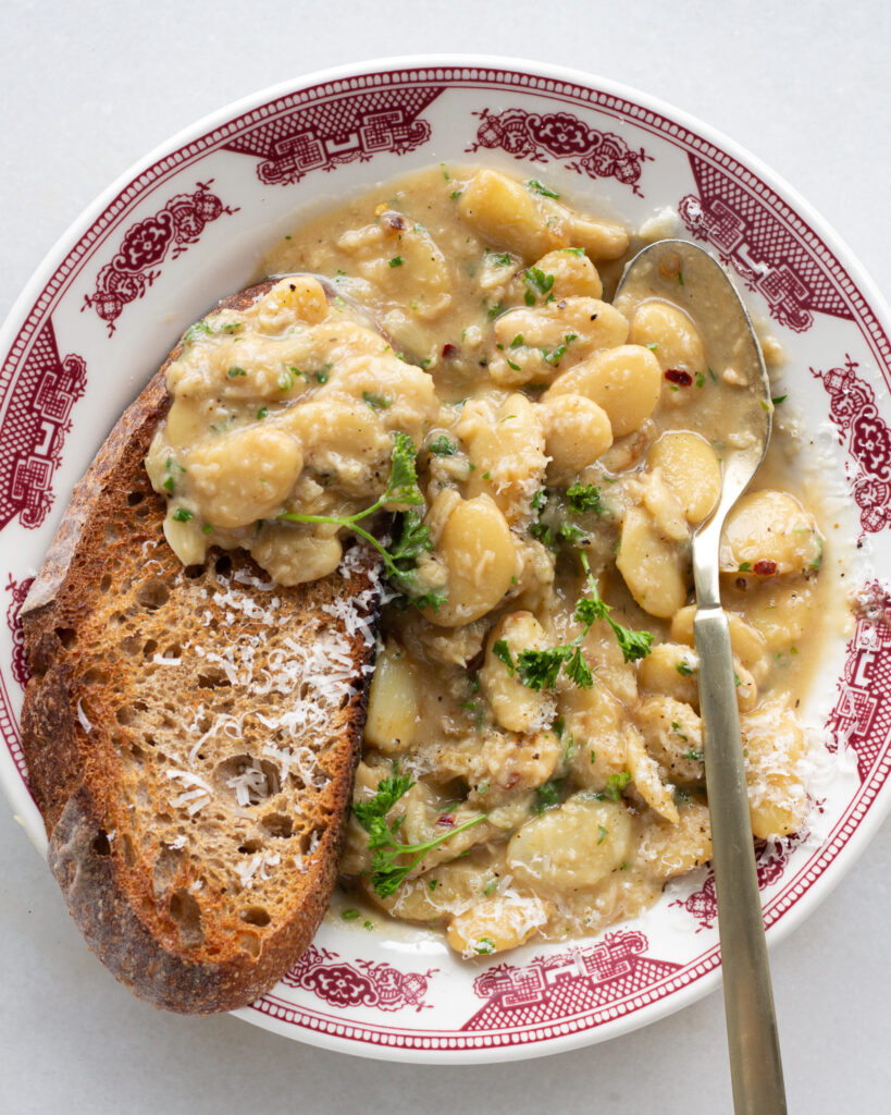 Garlic beans on toast served on a plate with a spoon