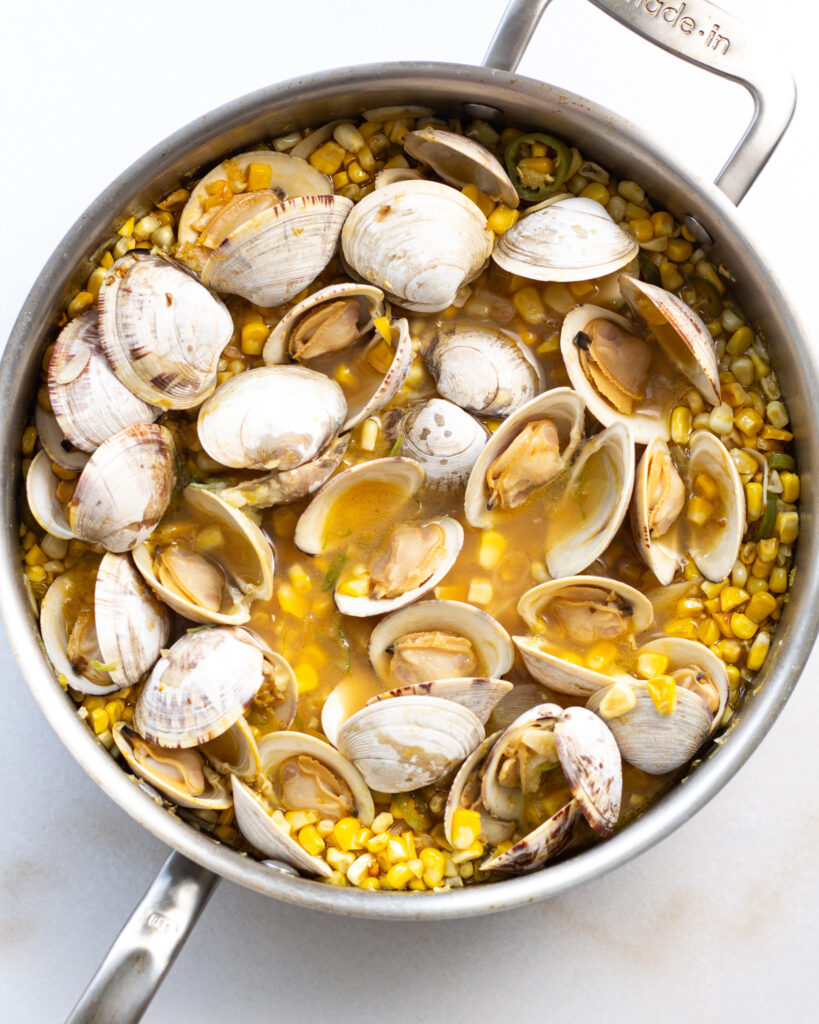 Clams and corn cooking in pan