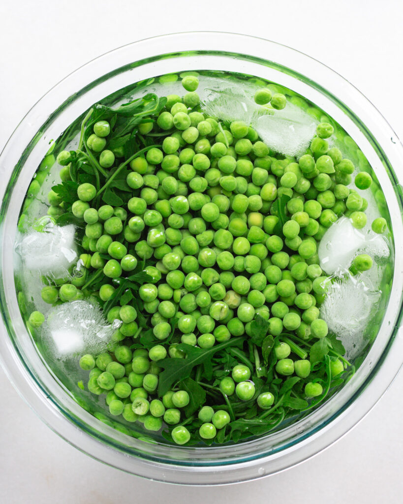 peas, arugula and parsley in ice bath