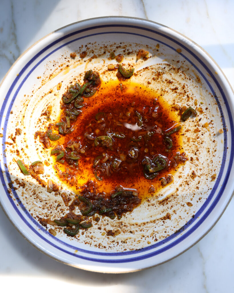 a sizzled scallion and ancho chili dressing in a bowl
