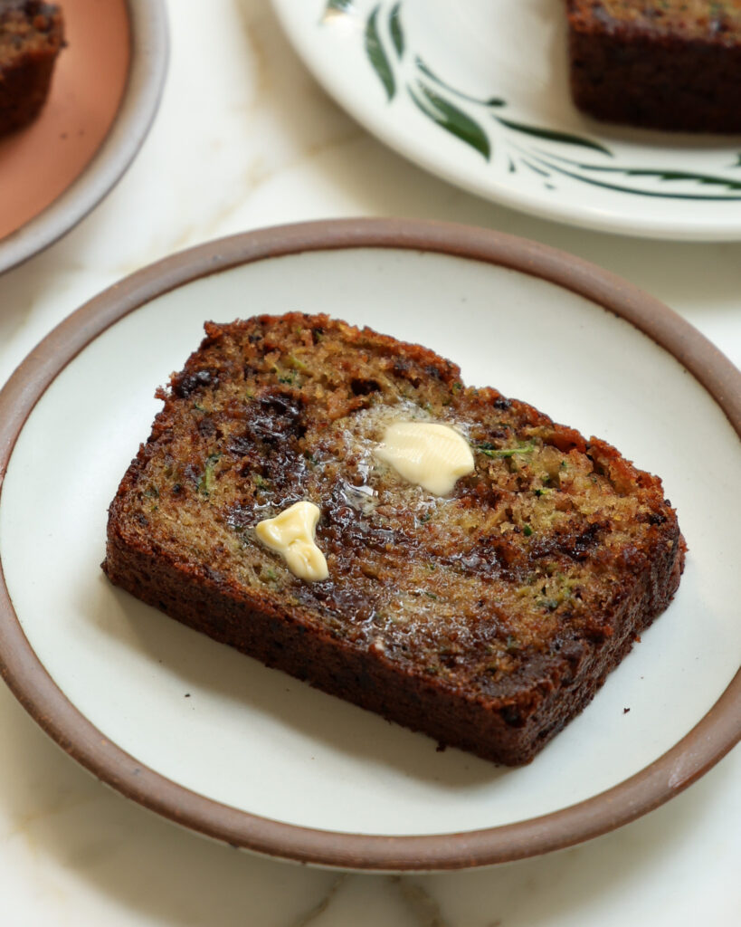 a slice of brown butter zucchini bread with melted butter
