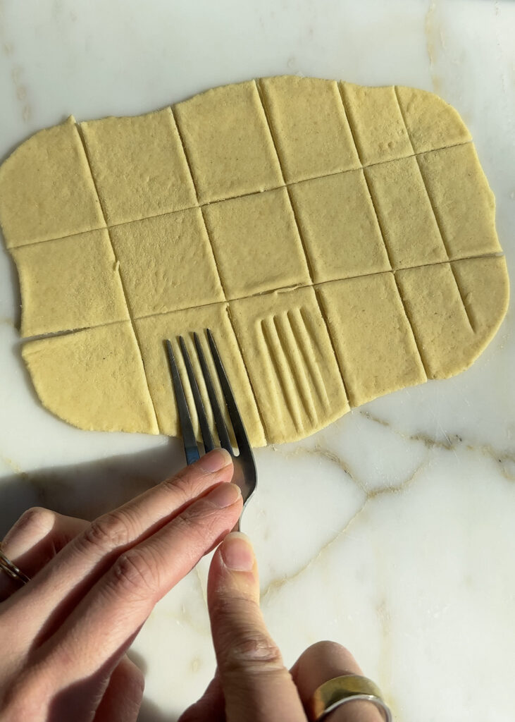 shaping homemade ravioli with a fork.