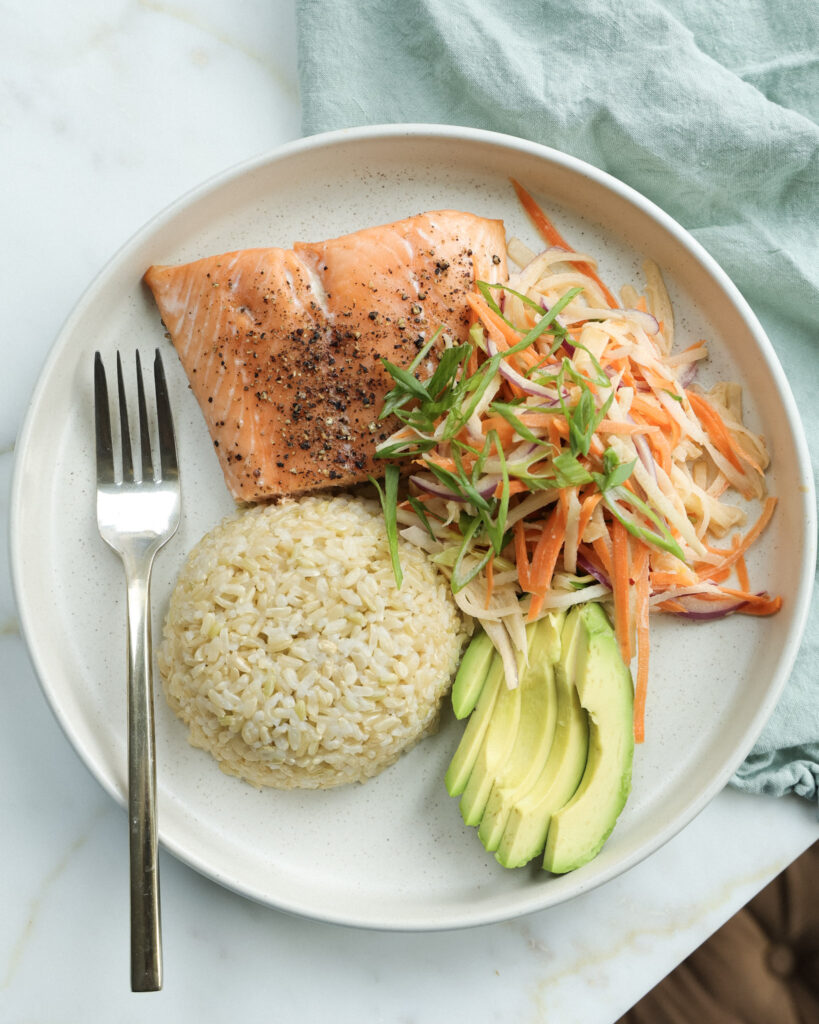 daikon radish slaw served alongside salmon, rice and avocado.