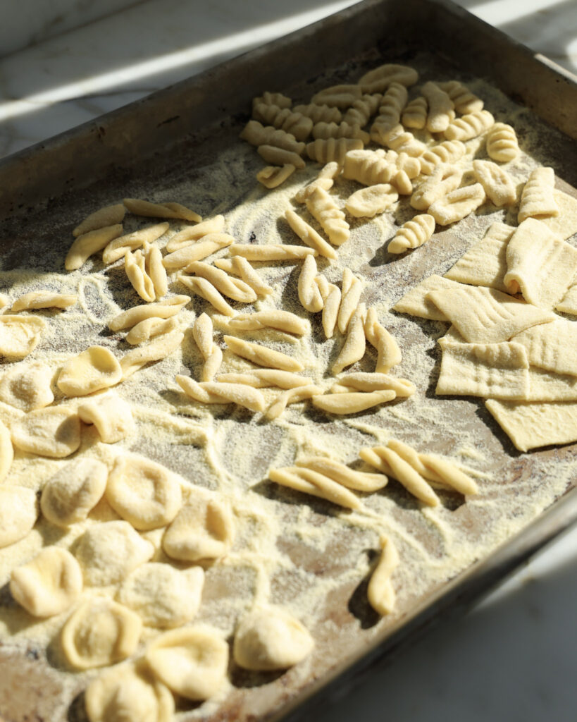 homemade pasta on a baking sheet dusted with semolina flour.