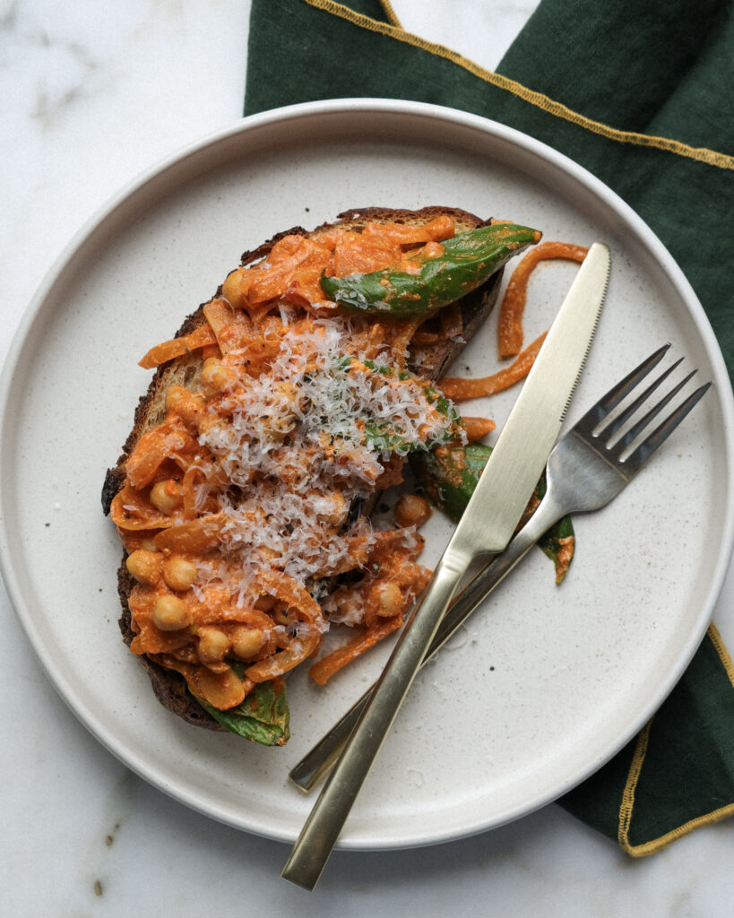 Chickpea alla vodka on toast topped with parmesan