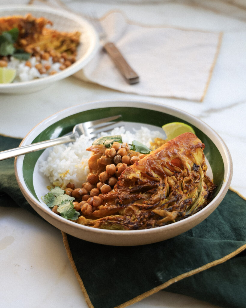 Braised cabbage with chickpeas and rice and a lime wedge.