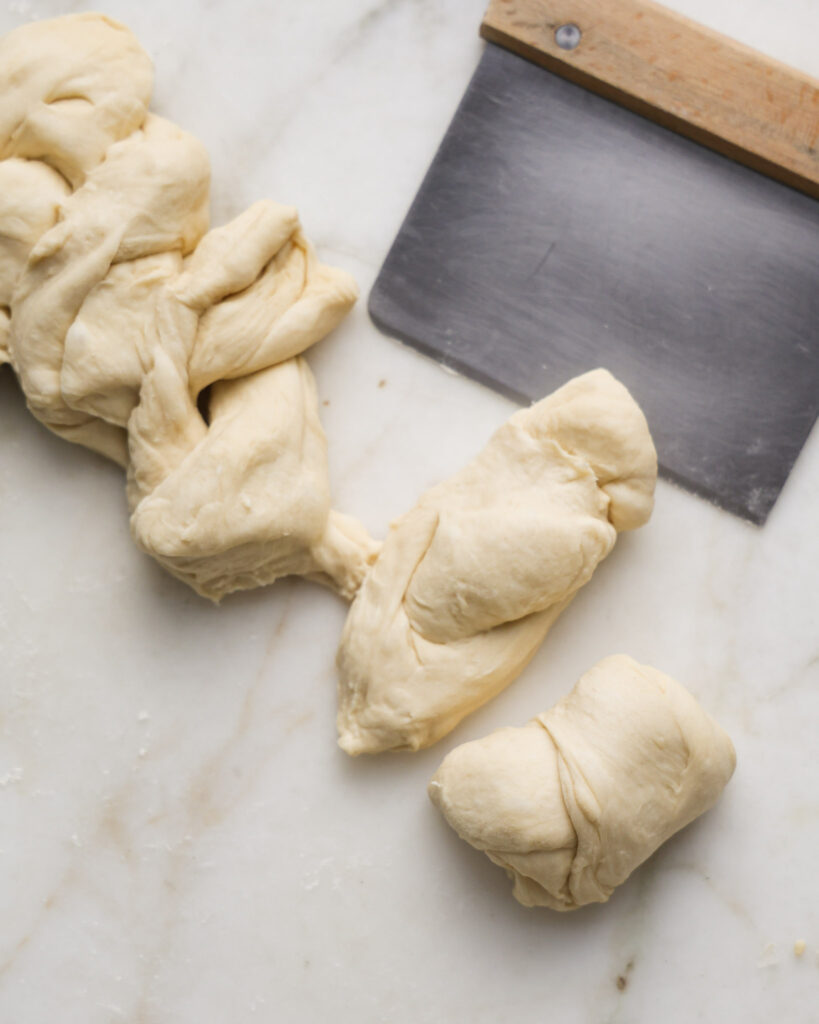 vegan brioche dough being shaped into a braided loaf.