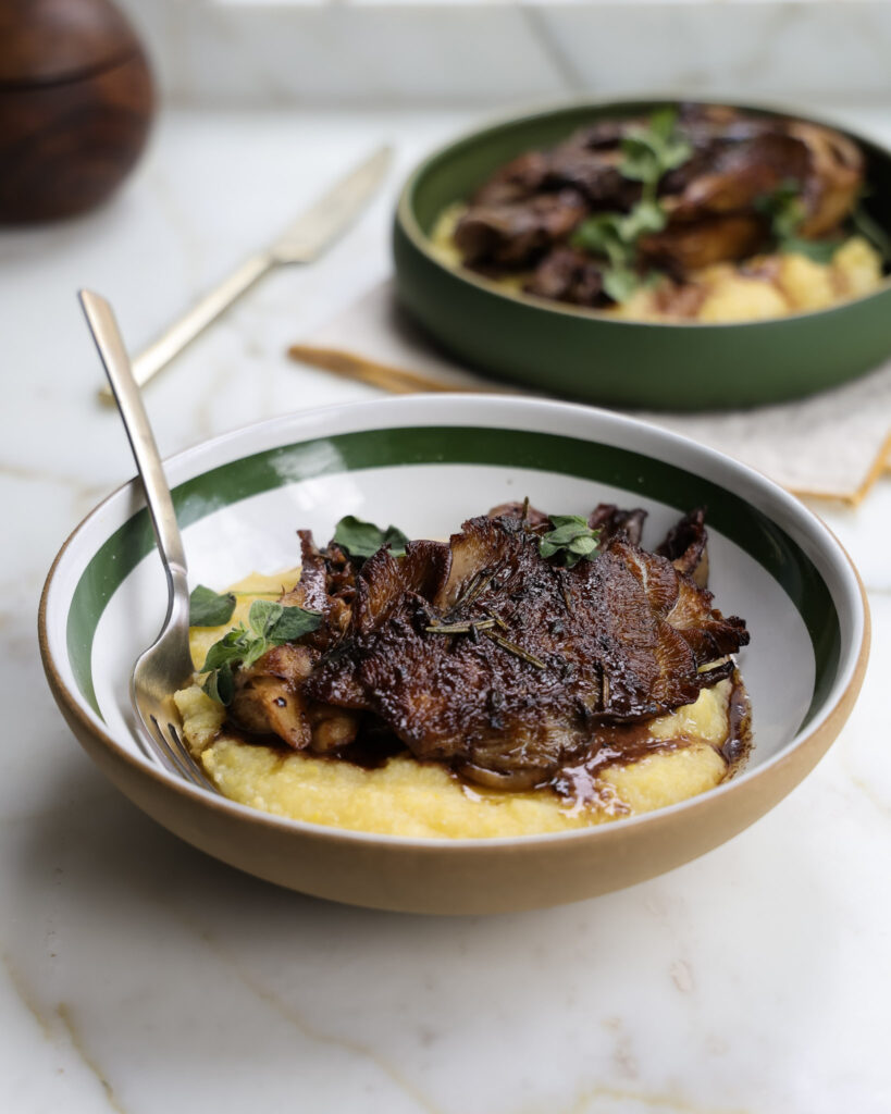 Mushroom Steaks over polenta in a bowl.