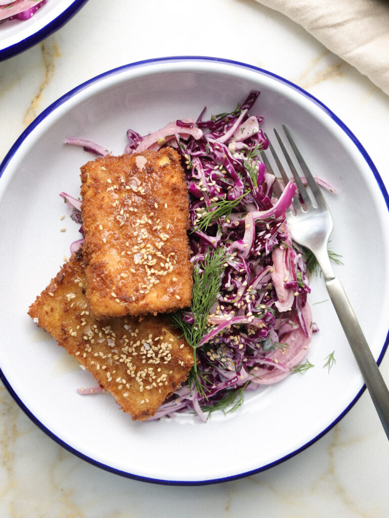 Tofu cutlets with slaw on a plate.
