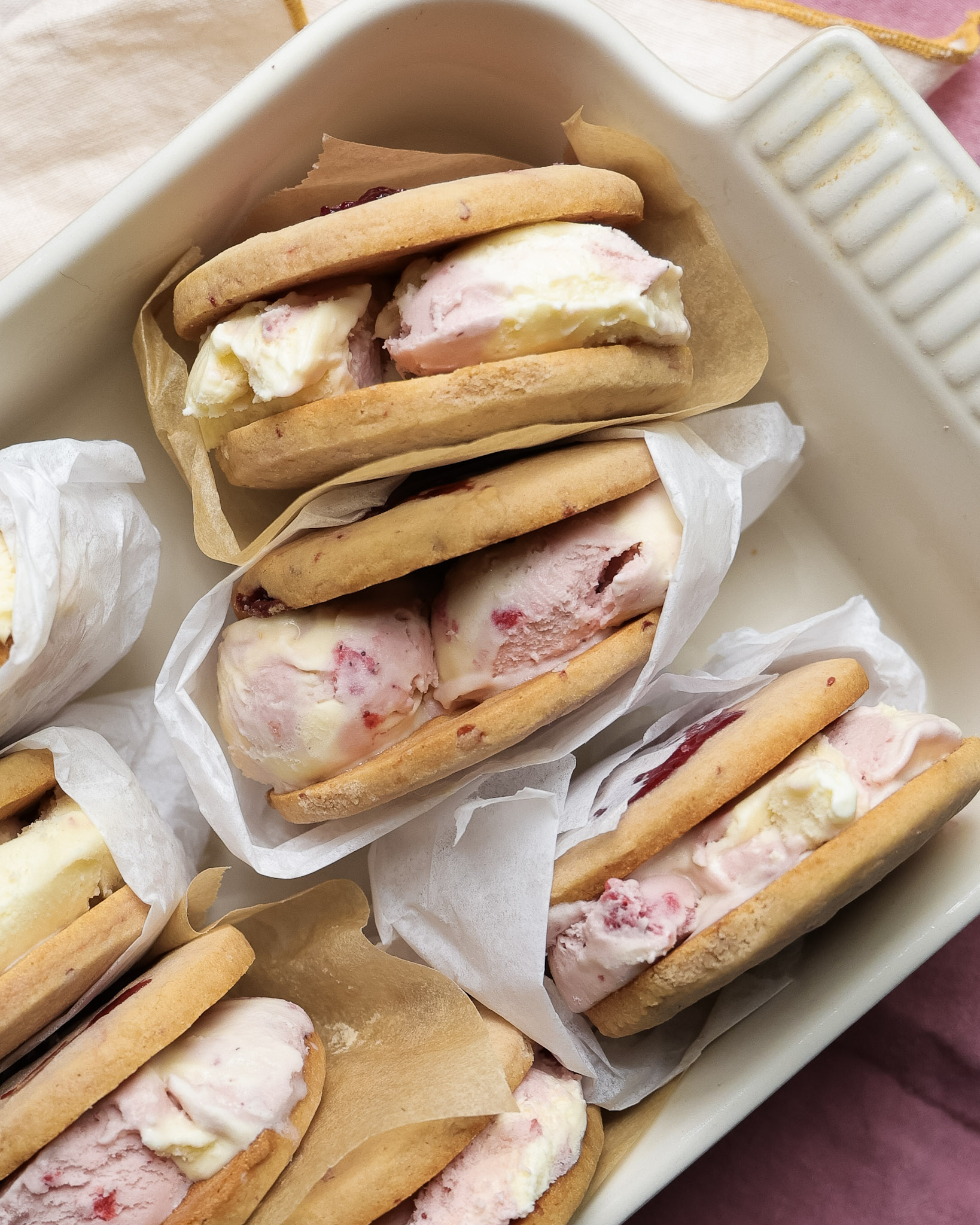 Strawberry ice cream sandwiches in a dish.