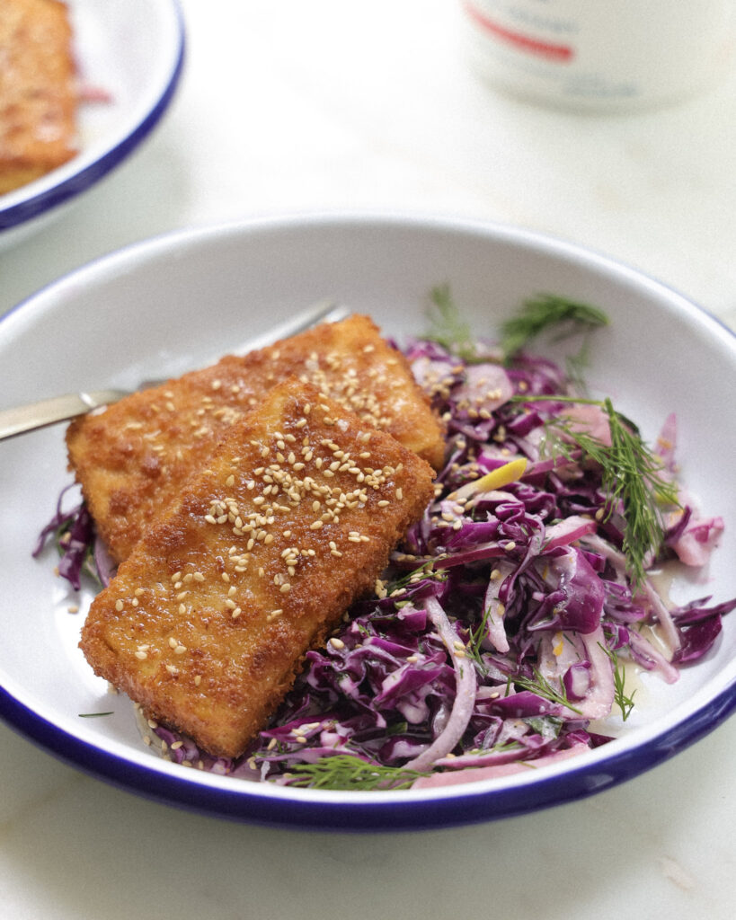 Tofu cutlets with slaw on a plate.