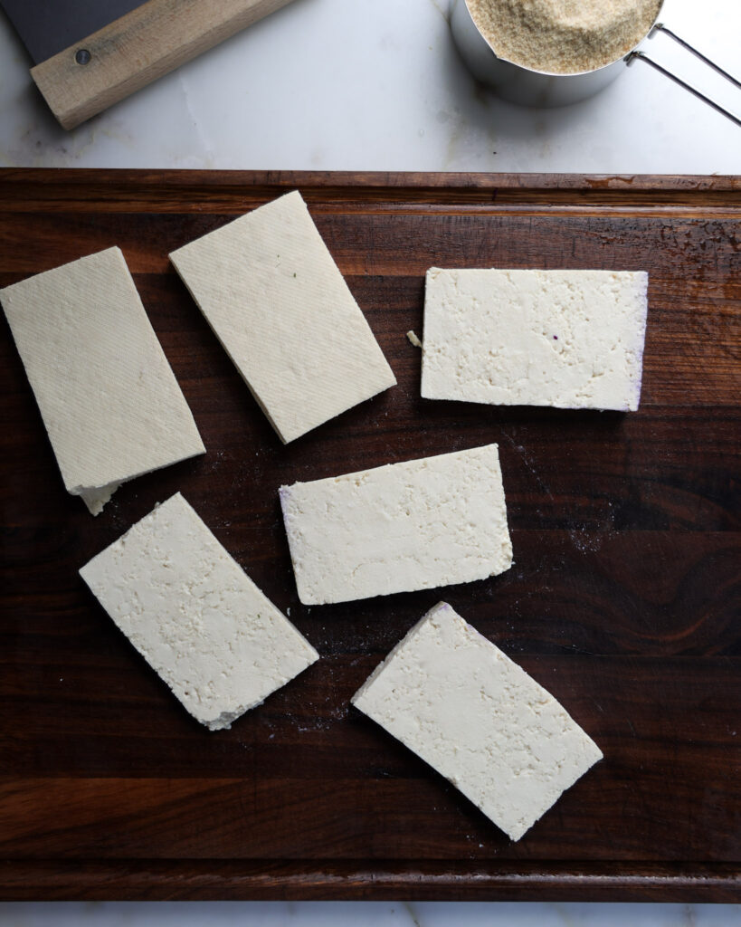 Slices of tofu on a cutting board.