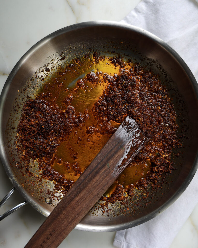 Paprika oil being cooked down in a pan.