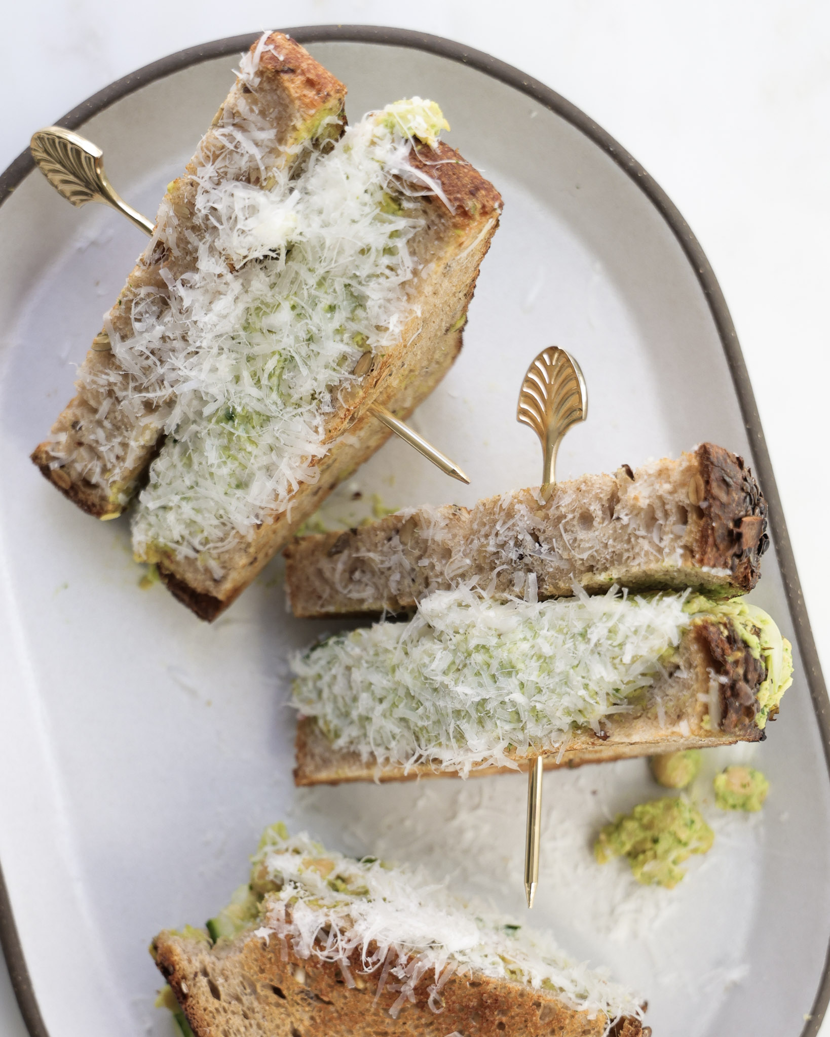 Chickpea salad sandwich cut in half and dipped in parmesan.