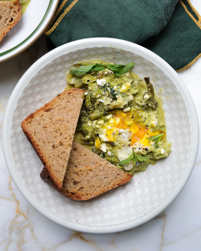 a bowl of green shakshuka with toast