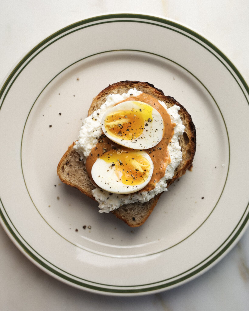 soft boiled eggs over romesco and whipped ricotta toast.