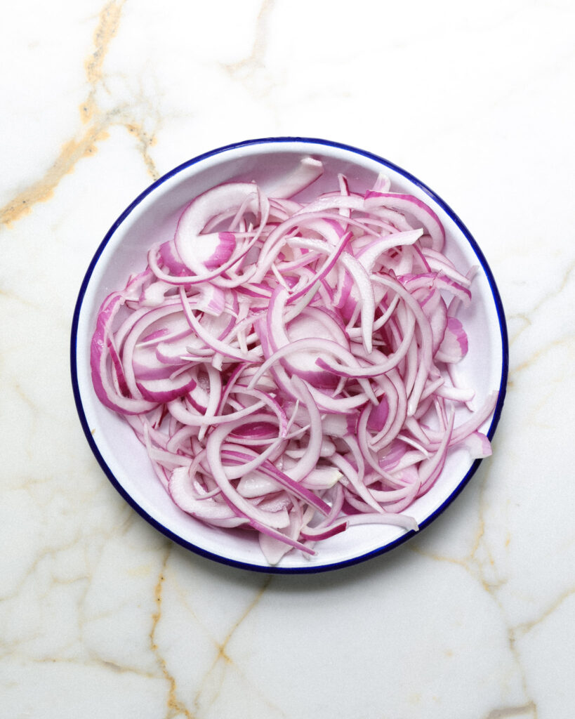 Thinly sliced red onions.