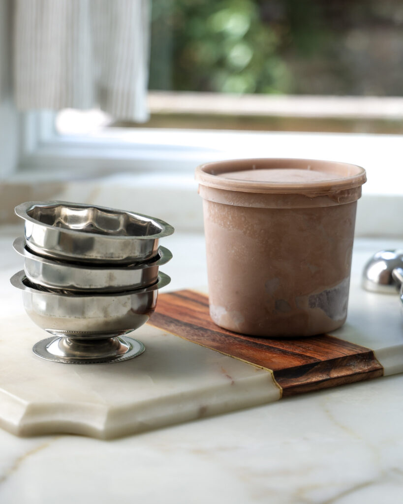 Homemade chocolate ice cream in a quart container.