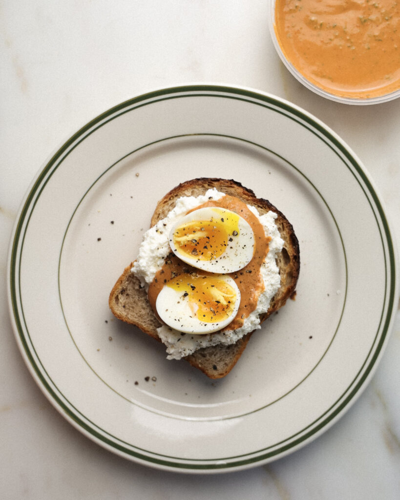 soft boiled eggs over romesco and whipped ricotta toast.