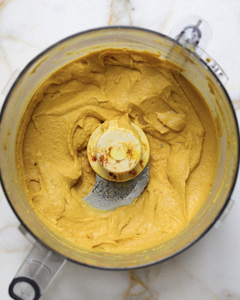 Golden hummus in a food processor.