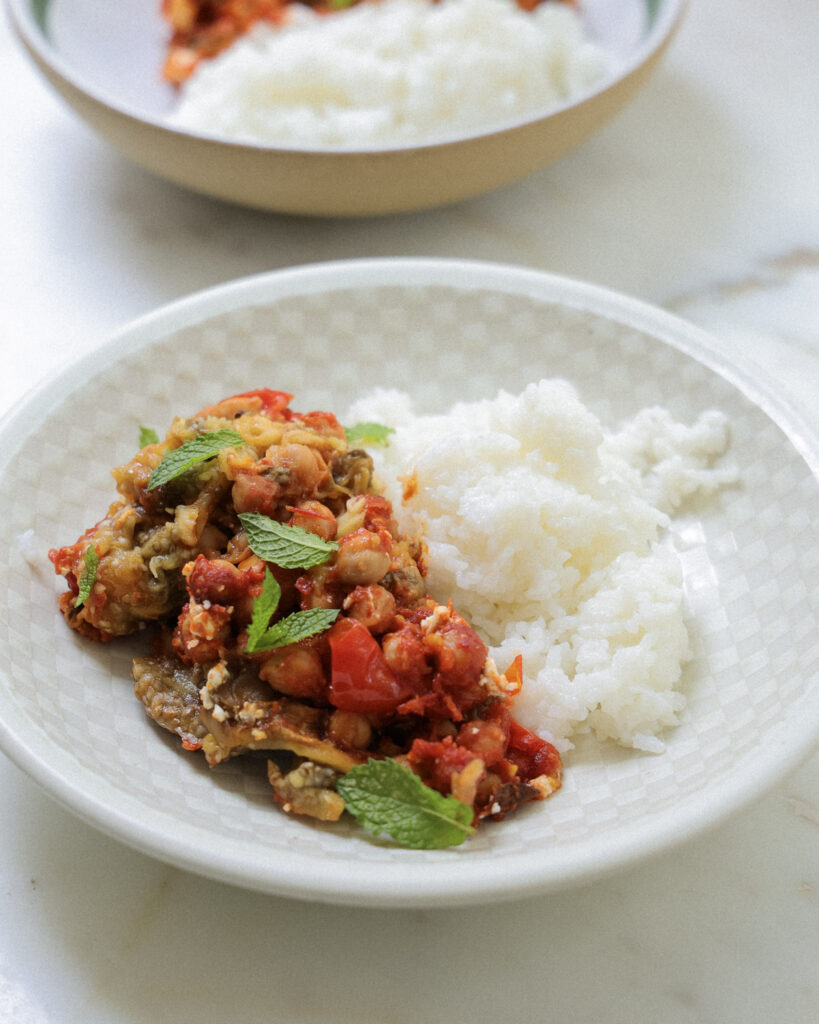 Harissa eggplant and chickpeas in a bowl with white rice.