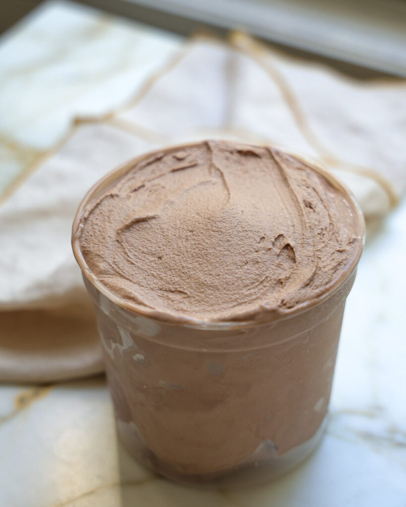 Homemade chocolate ice cream in a quart container.
