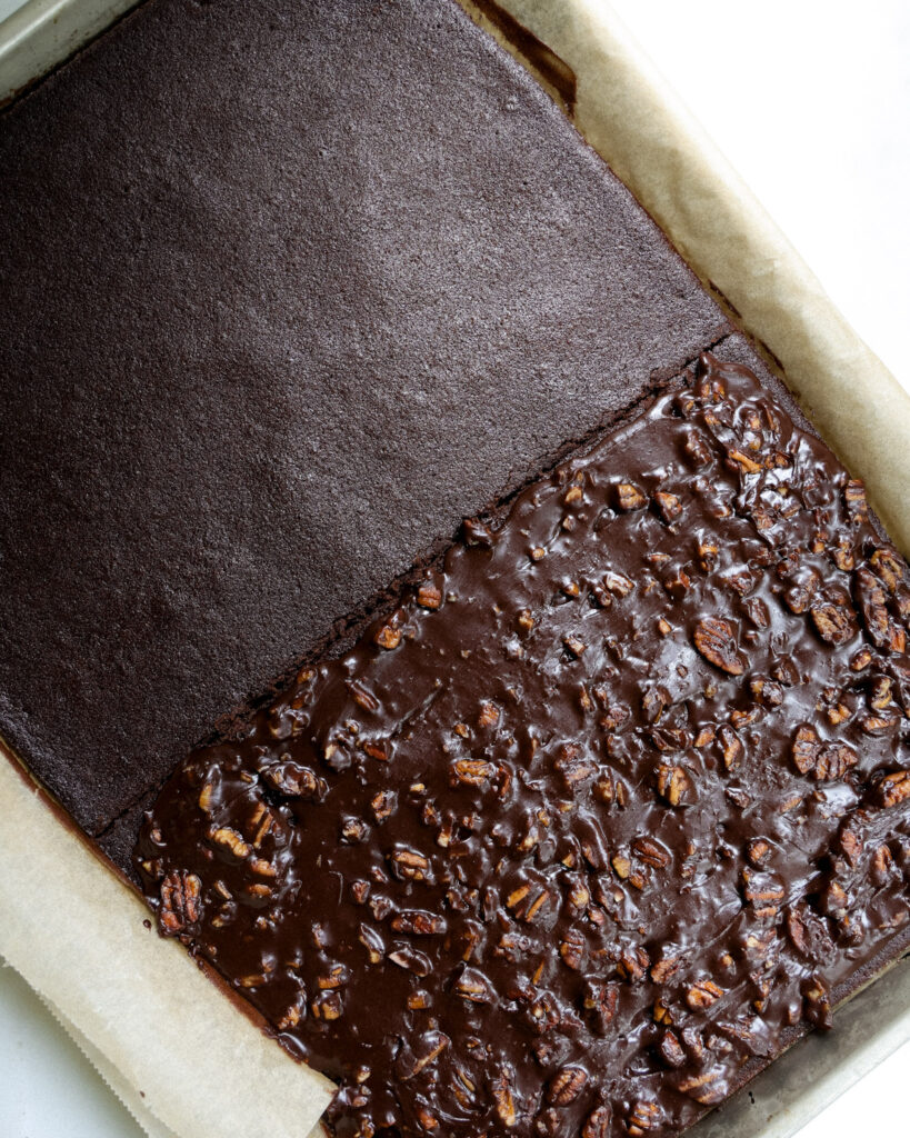 texas sheet cake sliced in half on a baking sheet.