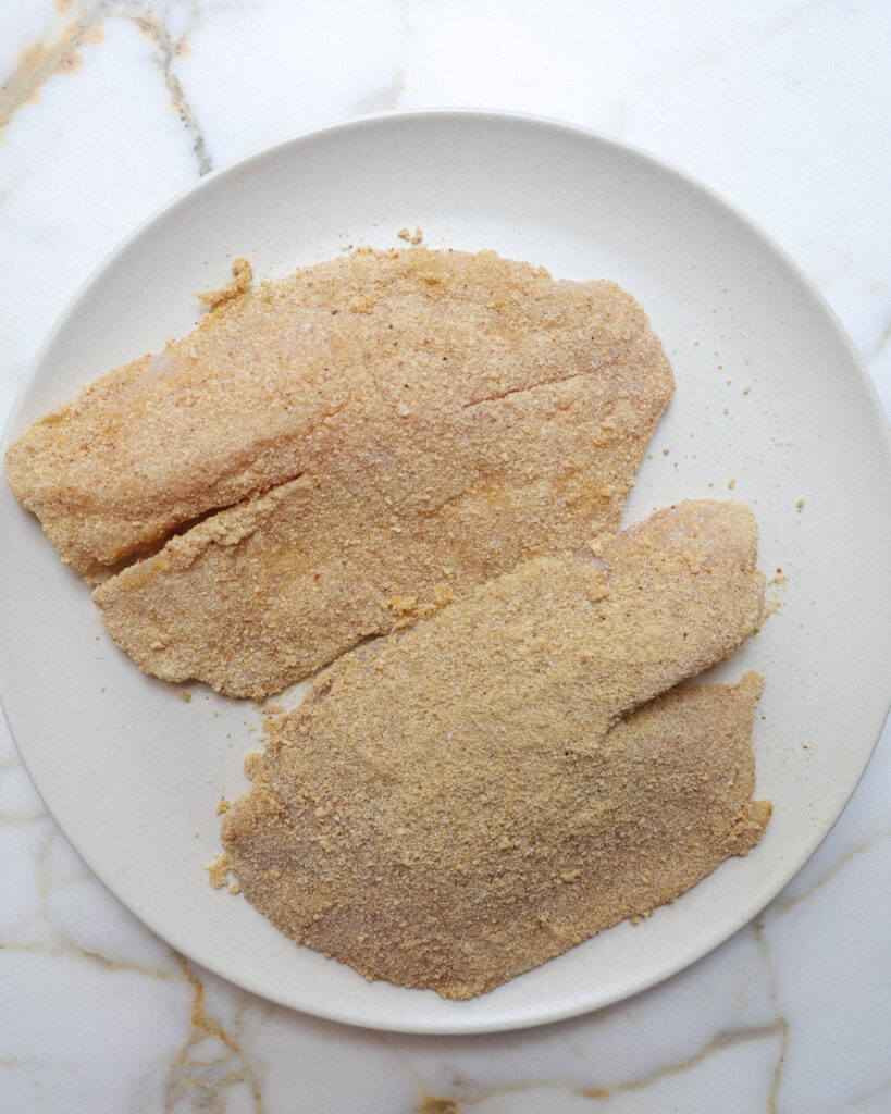 Raw halibut dredged in breadcrumbs