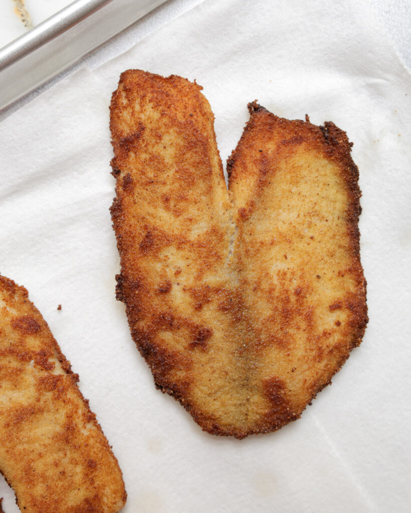 Fried halibut on a paper towel.
