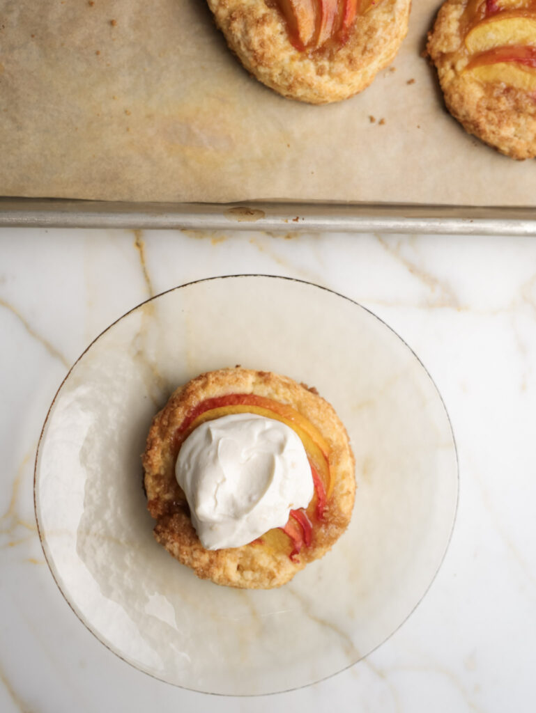 Peach shortcakes topped with whipped cream.