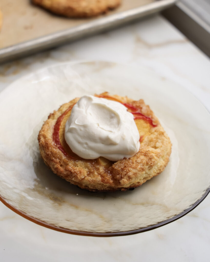 Peach shortcakes topped with whipped cream.