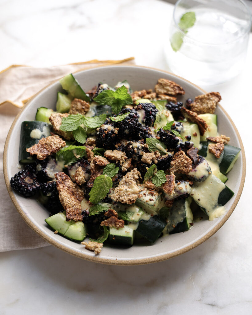 Smashed cucumber and blackberry salad in a bowl.