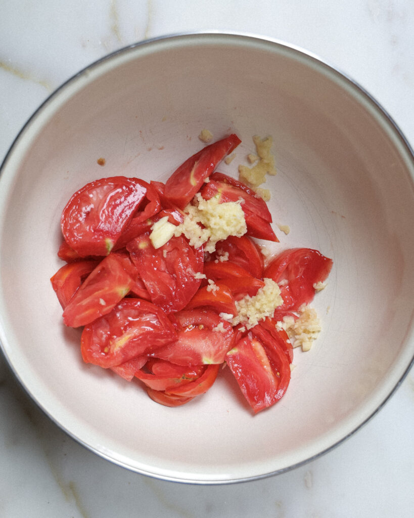 sliced tomatoes and garlic in a bowl.